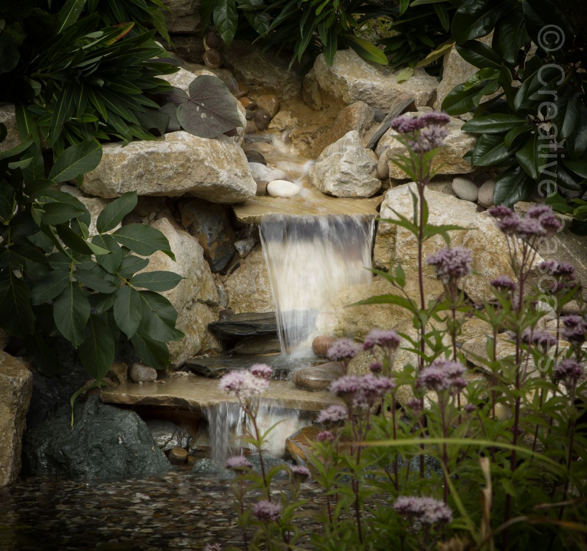 Clients wanted us to incorporate some old patio flags into this waterfall which is set-off nicely with native Hemp flowers  - Landscaping and Water Features -  Creative Cascades