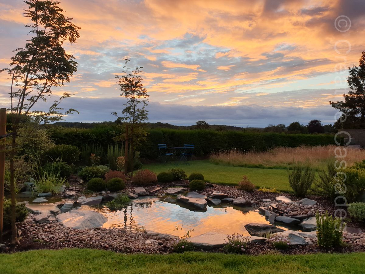 Sunset over a pond we built near Bishops Stortford, in time plants will soften the rocky appearance  - Landscaping and Water Features -  Creative Cascades