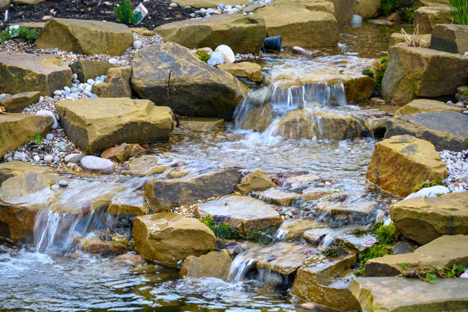 Close-up of yorkstone cascades, the trick is to avoid a waterfall 'staircase', by splitting the watercourse and adding multiple cascades pointing in different directions. This takes many years of practice.  - Landscaping and Water Features -  Creative Cascades